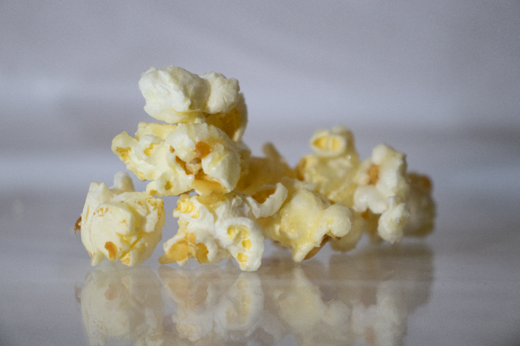 Nahaufnahme von karamellisiertem Popcorn auf spiegelndem Untergrund.
